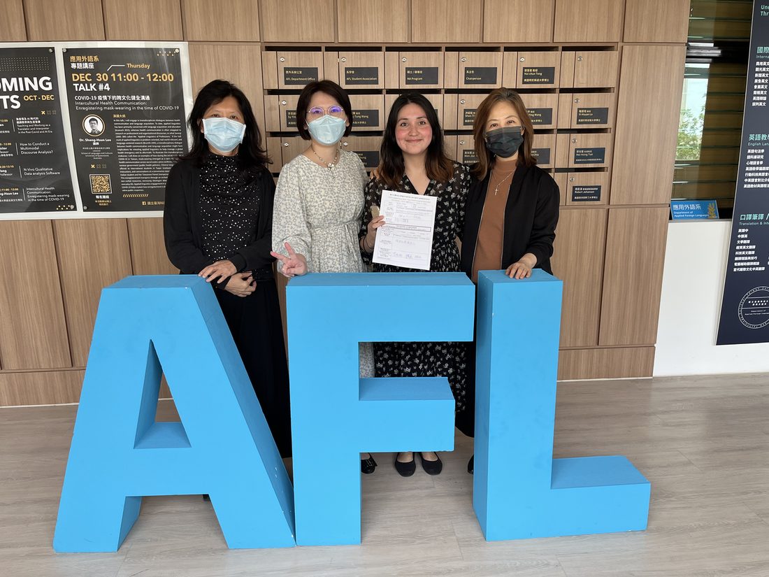 Paulina with colleagues beside large AFL letters at NTUST